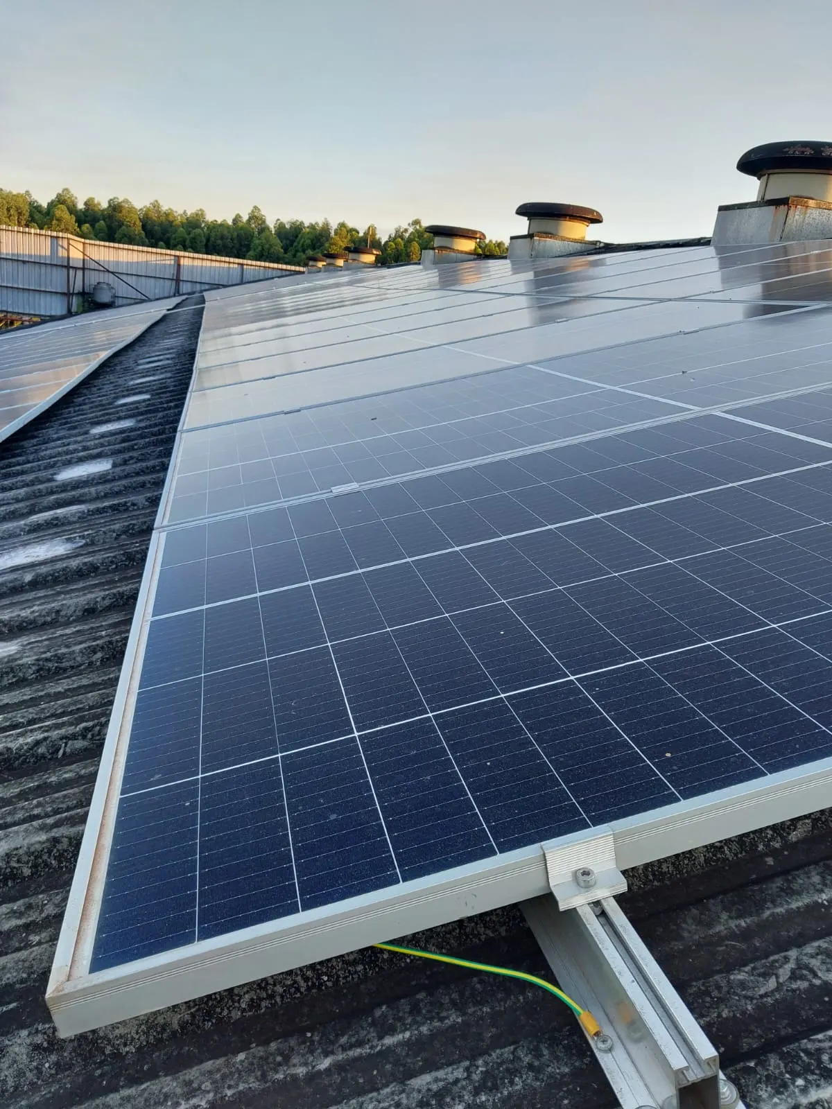 Detalle de la fijación de un panel solar sobre el riel de montaje y su puesta a tierra